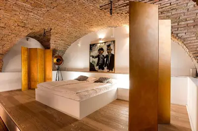 a bedroom with a bed in a brick wall at Dungeon Apartment in Ljubljana