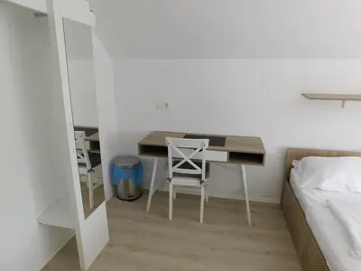 a desk in a bedroom with a bed and a desk at Evi Rooms Ljubljana in Ljubljana