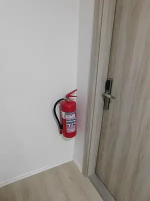 a fire extinguisher hanging on a wall next to a door at Evi Rooms Ljubljana in Ljubljana