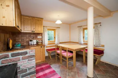 a kitchen with a table and chairs in a room at Holiday Home Voje in Bohinj