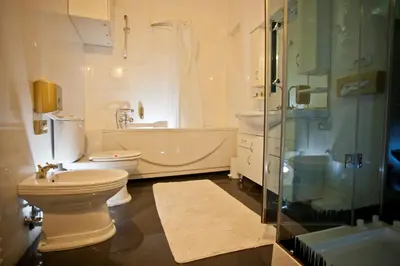 a bathroom with a toilet and a tub and a sink at Antiq Palace - Historic Hotels of Europe in Ljubljana