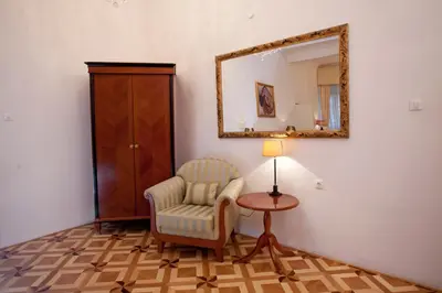 a living room with a chair and a mirror at Antiq Palace - Historic Hotels of Europe in Ljubljana