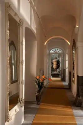 a hallway of a building with a vase with flowers at Antiq Palace - Historic Hotels of Europe in Ljubljana