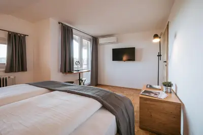a bedroom with a bed and a tv on the wall at Pri Karlu Rooms & More in Maribor