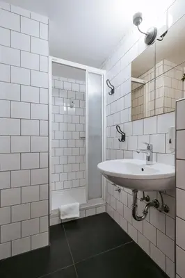 a white bathroom with a sink and a shower at Pri Karlu Rooms & More in Maribor