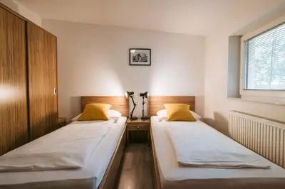 two beds in a small room with a window at Pri Karlu Rooms & More in Maribor