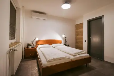 a bedroom with a large bed with a wooden headboard at Pri Karlu Rooms & More in Maribor