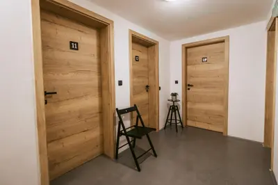 a room with two wooden doors and a chair at Pri Karlu Rooms & More in Maribor
