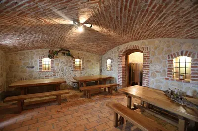 a room with benches and tables in a building at Vineyard cottage Zidanca med vinogradi in Otočec