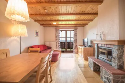 a living room with a table and a fireplace at Apartmajsko naselje Ribniško Pohorje in Ribnica na Pohorju