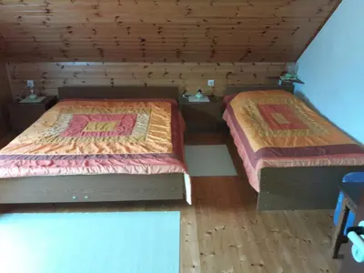 two beds in a room with wooden floors at Apartments Rozi in Bovec
