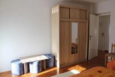 a living room with a wooden cabinet and a table at Apartments Rozi in Bovec