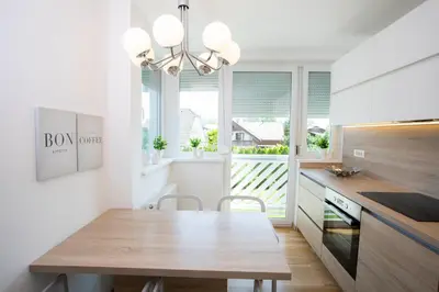 a kitchen with a wooden table and a dining room at Apartments Agenija Bled in Bled