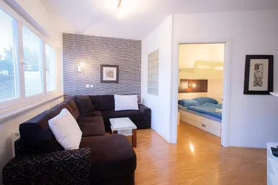 a living room with a couch and a bedroom at Apartments Agenija Bled in Bled