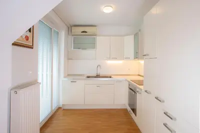 a kitchen with white cabinets and a sink at Apartments Agenija Bled in Bled