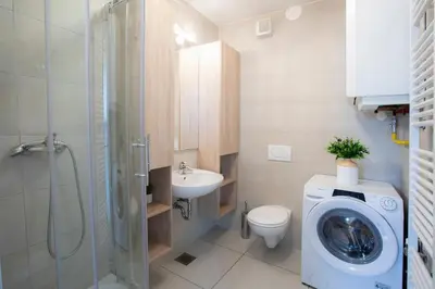 a bathroom with a washing machine and a sink at Apartments Agenija Bled in Bled
