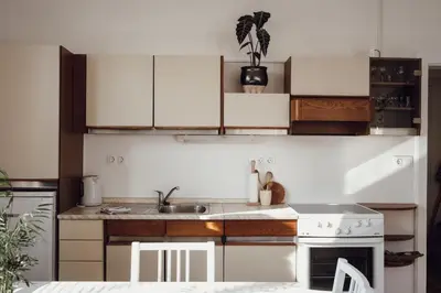 a kitchen with white cabinets and a sink and a stove at Rural Carniola fairytale in Križe