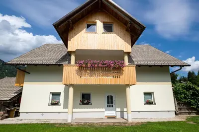 a house with a balcony with flowers on it at TriSa apartments Bohinj in Bohinj