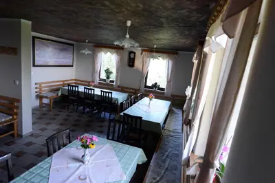 a dining room with tables and chairs with flowers on them at Apartment House Koprivnik in Zreče