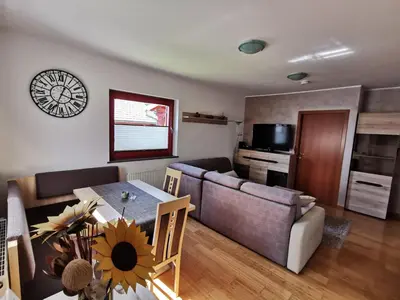 a living room with a table and a couch at Apartma NEVA in Bohinj