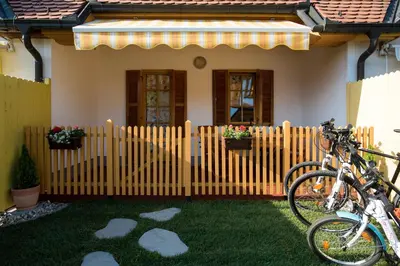 two bikes parked in front of a house with a fence at Apartma Marjetica 2 in Moravske Toplice