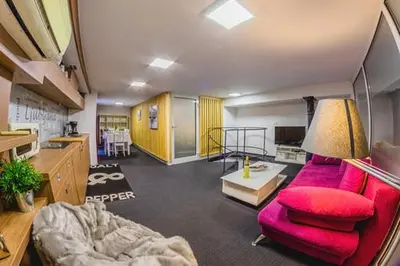 a living room with a red couch and a table at Tržaška Duplex Urban Apartment in Ljubljana