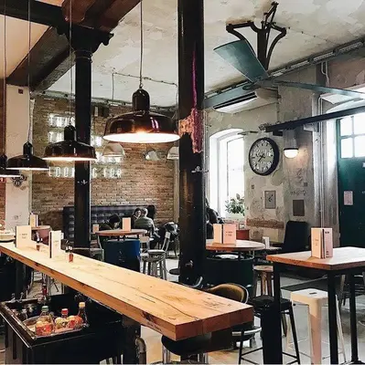 a large room with tables and a clock on the wall at Tržaška Duplex Urban Apartment in Ljubljana