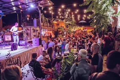 a crowd of people watching a man on a stage at Tržaška Duplex Urban Apartment in Ljubljana