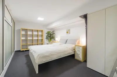 a bedroom with a white bed and a yellow cabinet at Tržaška Duplex Urban Apartment in Ljubljana