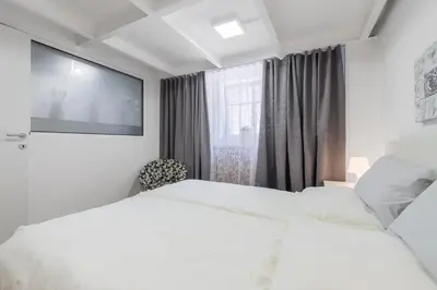 a hotel room with two beds and a flat screen tv at Tržaška Duplex Urban Apartment in Ljubljana
