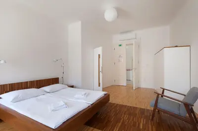 a bedroom with a bed and a chair and a chalkboard at Julija&Robert's Riverview Apartments and Rooms in Ljubljana