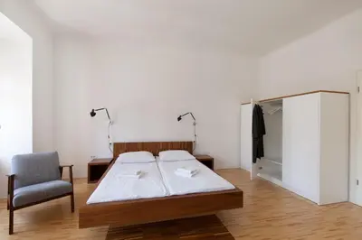 a bedroom with a bed and a chair in it at Julija&Robert's Riverview Apartments and Rooms in Ljubljana