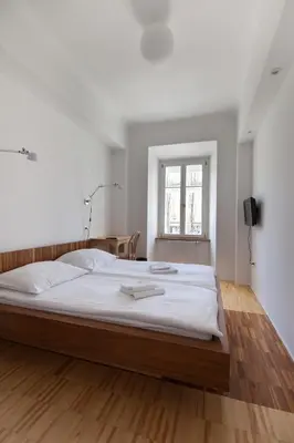 a bedroom with a large bed with white sheets at Julija&Robert's Riverview Apartments and Rooms in Ljubljana