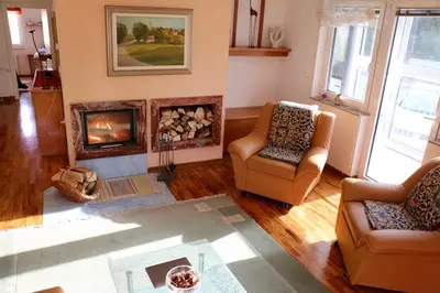 a living room with two chairs and a fireplace at Cosy apartment in Kranjska Gora
