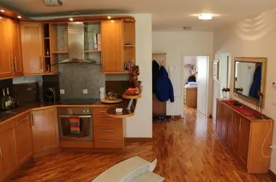 a kitchen with wooden cabinets and wooden floors at Cosy apartment in Kranjska Gora