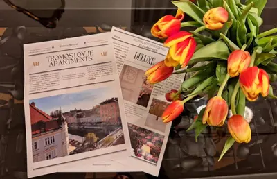 a bouquet of tulips in a vase with pictures at Tromostovje apartments in Ljubljana