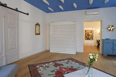 a living room with a table and a blue ceiling at Tromostovje apartments in Ljubljana