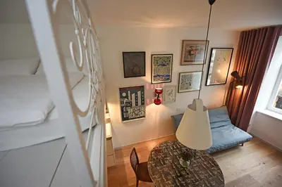a room with a bed and a table with a lamp at Tromostovje apartments in Ljubljana