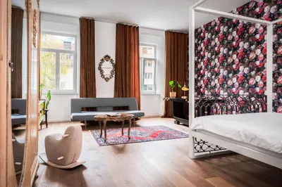 a bedroom with a bed and a chair and a table at Tromostovje apartments in Ljubljana