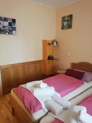 a bedroom with a large bed with pink sheets and towels at Apartment Bolfenk in Pohorje