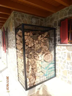a wall with a cage full of fire wood at Apartment Bolfenk in Pohorje