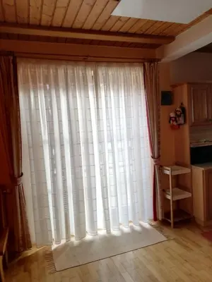 a large window with white curtains in a room at Apartment Bolfenk in Pohorje