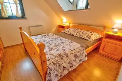 a bedroom with a wooden bed in a room at Apartment Sara in Vitanje