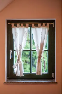 a window with white curtains in a room at Apartment Sara in Vitanje