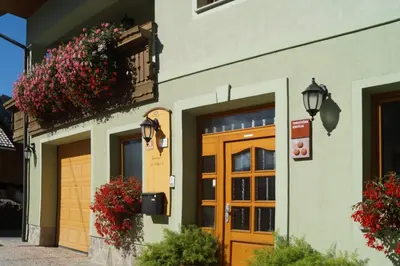 a building with a door and flowers on it at Apartmaji Hribar Pr'Ostank in Kamnik