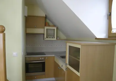a kitchen with wooden cabinets and a staircase at Apartmaji Hribar Pr'Ostank in Kamnik