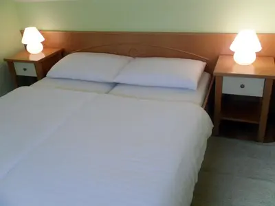 a bedroom with two beds and two lamps on tables at Apartmaji Hribar Pr'Ostank in Kamnik