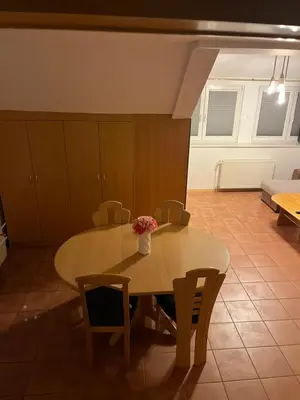 a dining room table with a vase of flowers on it at J-Max in Bled