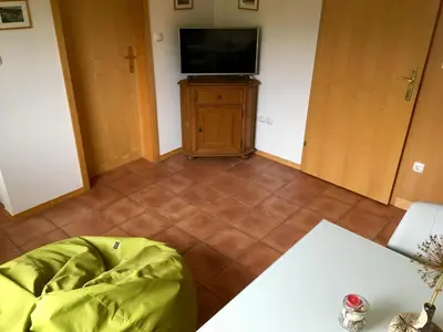 a living room with a television and a tiled floor at J-Max in Bled