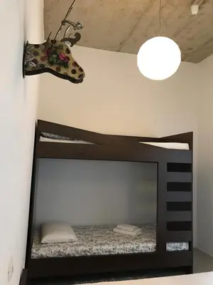 a room with a bed with a headboard and a butterfly on the wall at Street Flat in Ljubljana